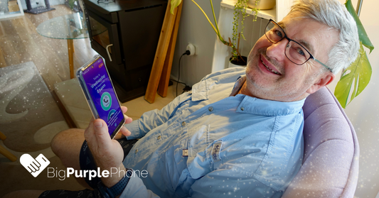 man holding a BigPurplePhone SilverFox Edition, happy and relaxed. BigPurplePhone features big buttons and simple user interface.